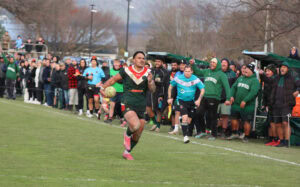 Danny Latu sprints down the touchline, supported by the crowd